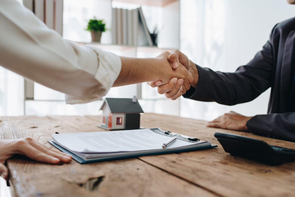 the bank's mortgage officers shake hands with customers to congratulate them after signing a housing investment loan agreement